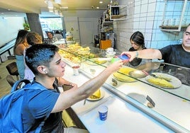 Un joven cliente abona su consumición en el Bodi de la Calle Amós de Escalante, en Santander.