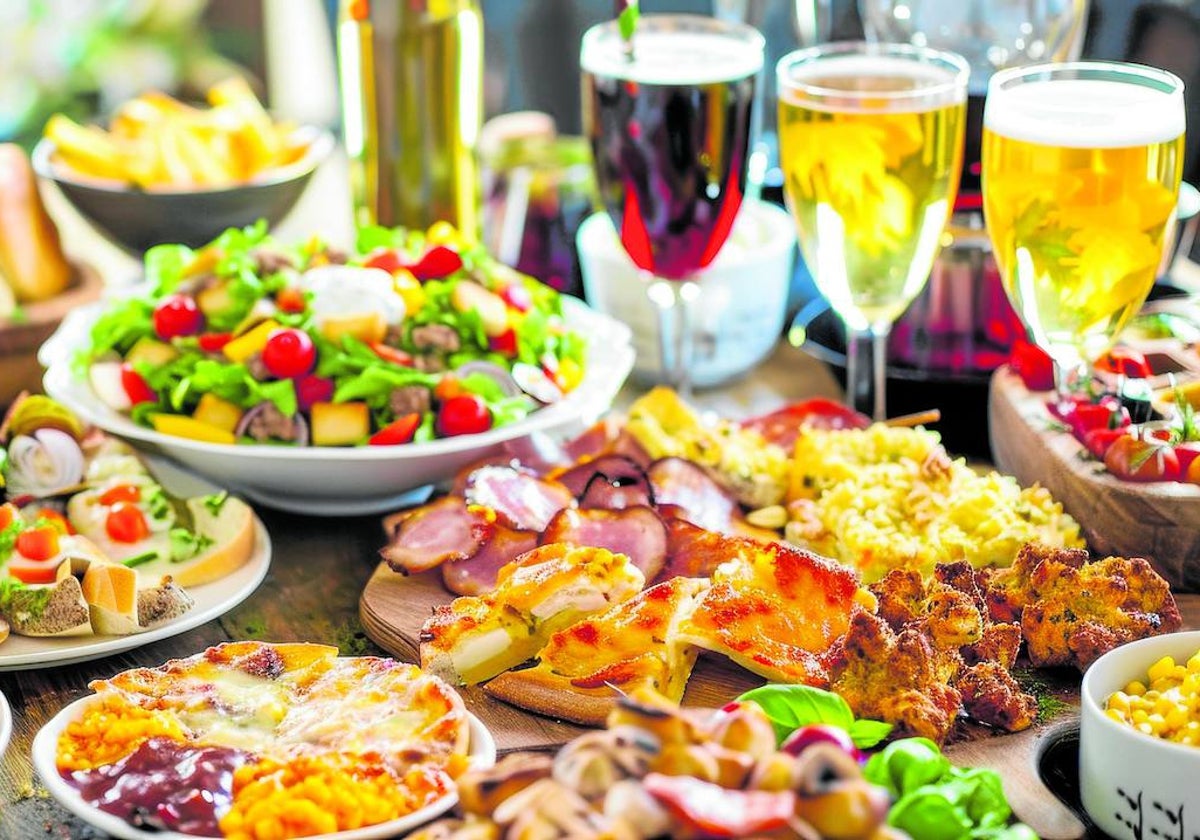 Diferentes platos con alimentos con tres bebidas para poder elegir.