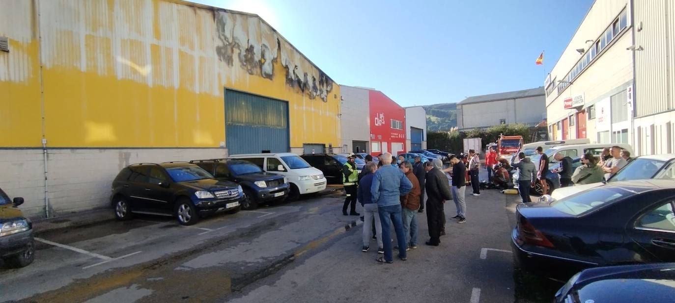 Las huellas del fuego en una de las fachadas de la nave. En el exterior, vecinos, trabajadores y efectivos movilizados por el 112