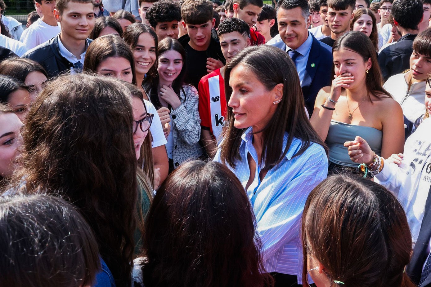 La Reina se ha mezclado con los alumnos en el patio del centro. Aquí se han roto todas las barreras y Doña Letizia ha compartido mano a mano con los estudiantes. Detrás se ve a Gurutze Carrión, muy emocionada tras haberle dado la mano a la monarca.