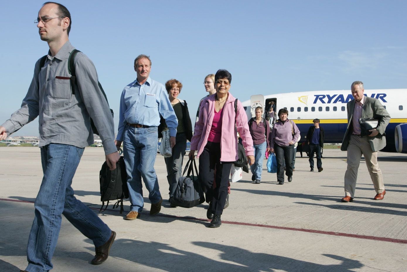 Los primeros pasajeros procedentes de Londres-Stanted descienden del avión Boeing 737 en el aeropuerto de Parayas.