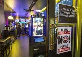 Un cartel avisa de la prohibición de entrar a menores en una sala de juegos de Santander.