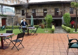 El histórico edificio del Casino de Buelna y parte de su gran terraza, con Carlos López, uno de los últimos responsables del bar.