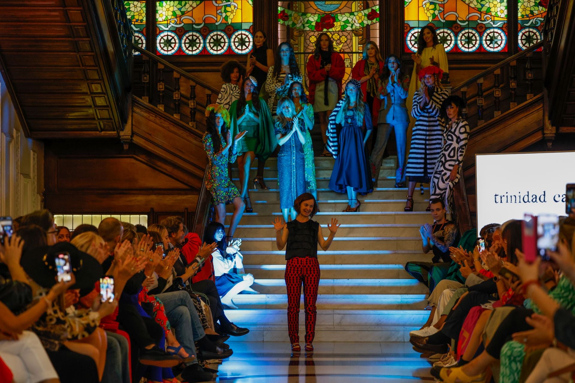 Trinidad Castillo saluda al público tras su desfile. En la escalinata del Casino, todas las modelos con sus diseños.