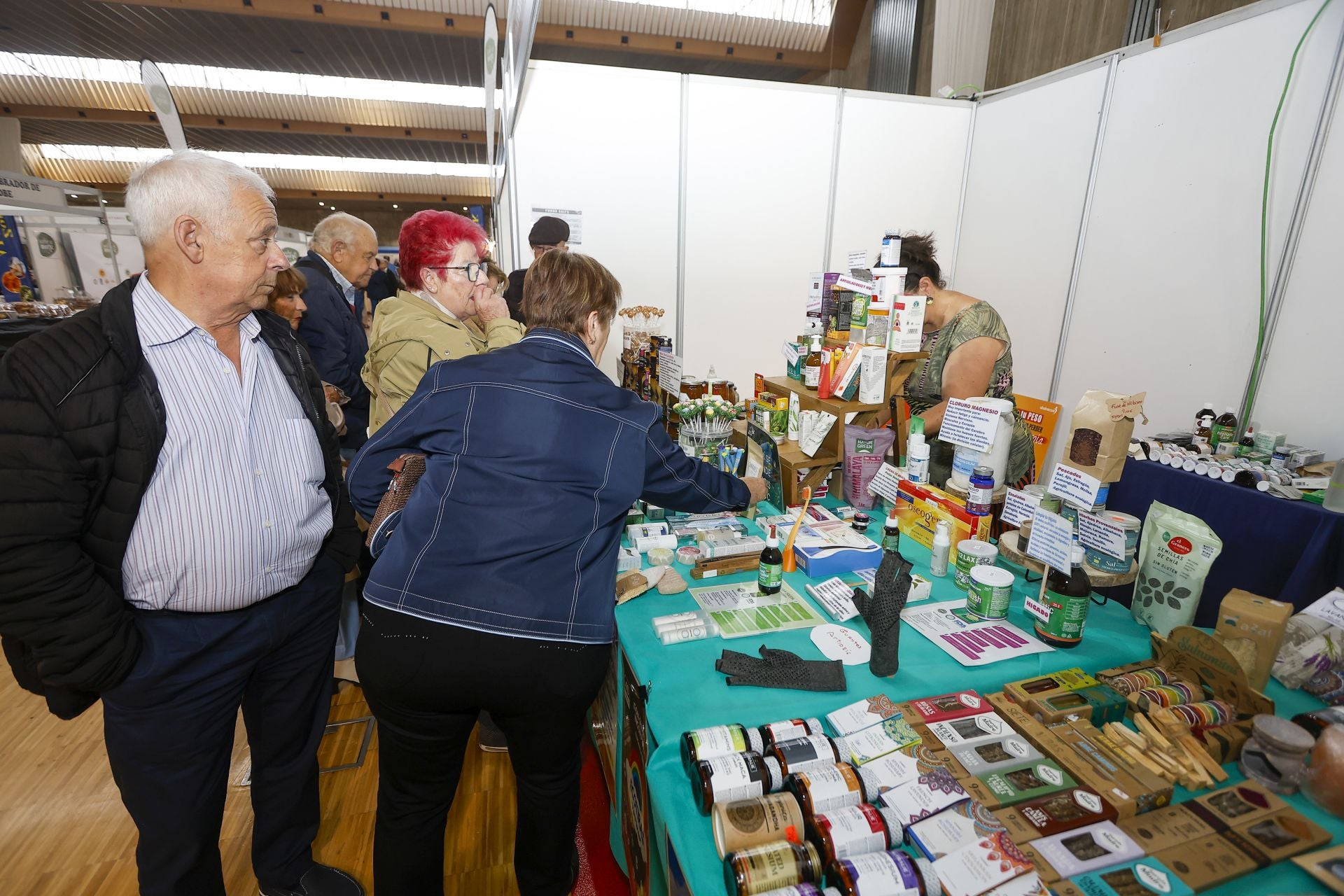 Varias personas se prueban los productos cosméticos a la venta en la feria.