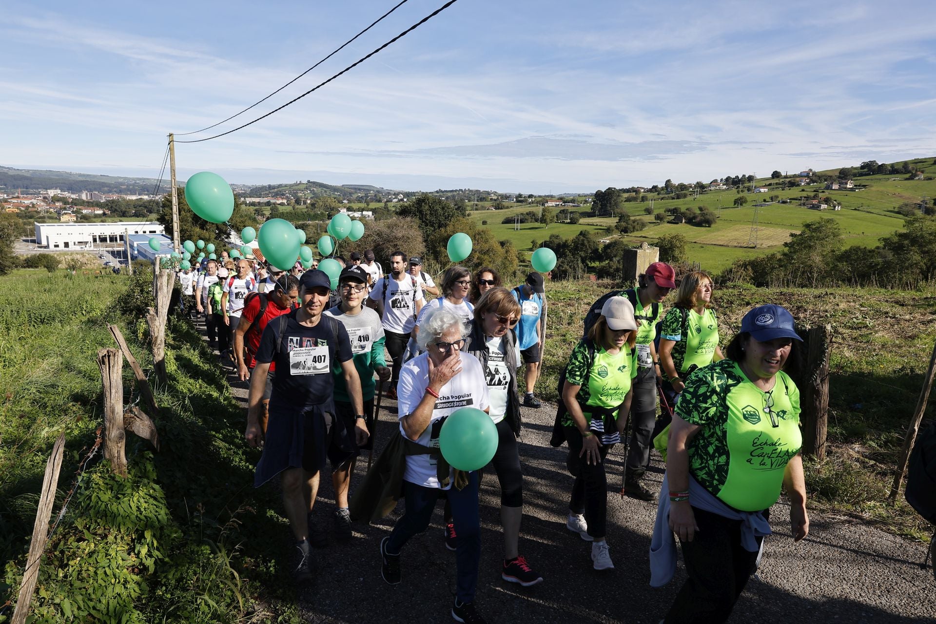 Participantes en la marcha atraviesan un camino vecinal. 