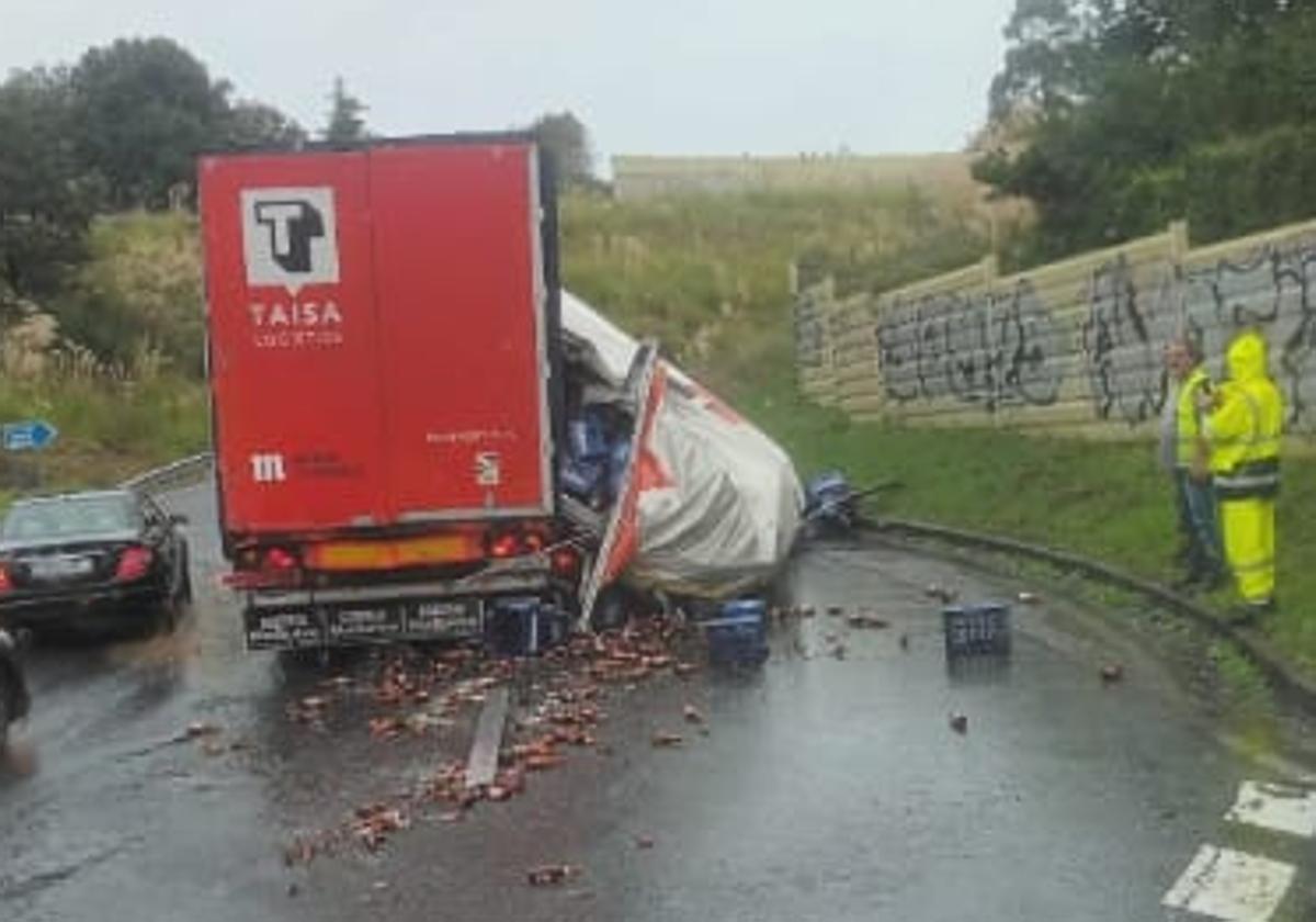 El camión accidentado y la mercancía desparramada por la rotonda.