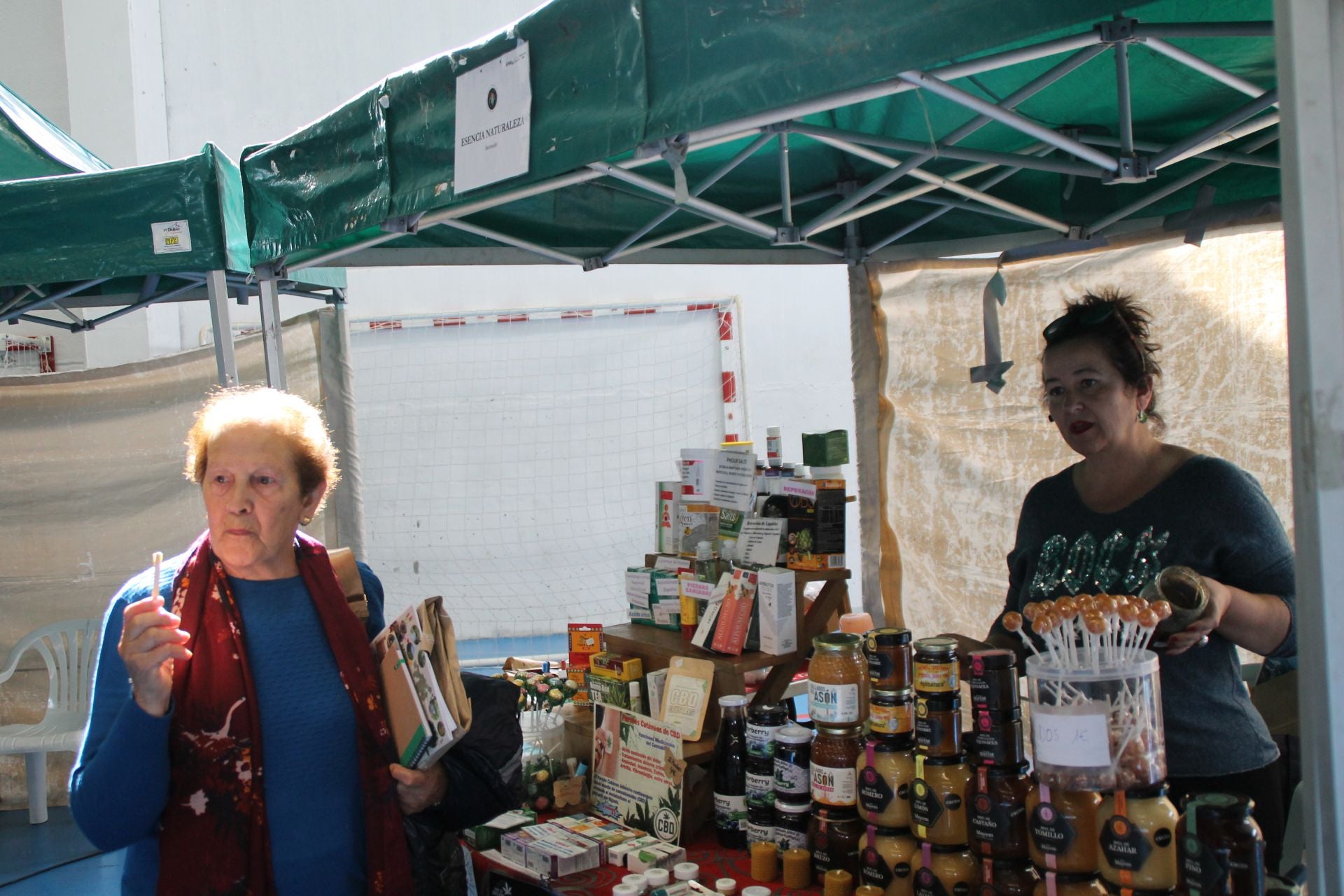 Una mujer realiza una cata de los productos de uno de los puestos.