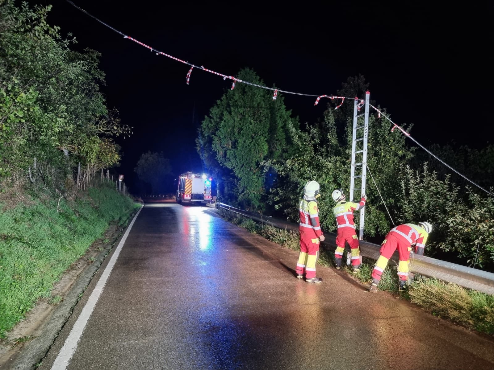 Bomberos del 112, anoche, tratando de sujetar unos cables desprendidos por el viento en Tama (Cillorigo de Liébana)