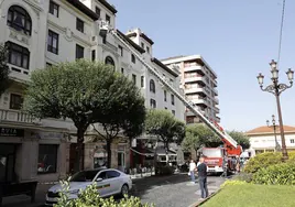 Los bomberos examinan la cornisa del edificio afectado.