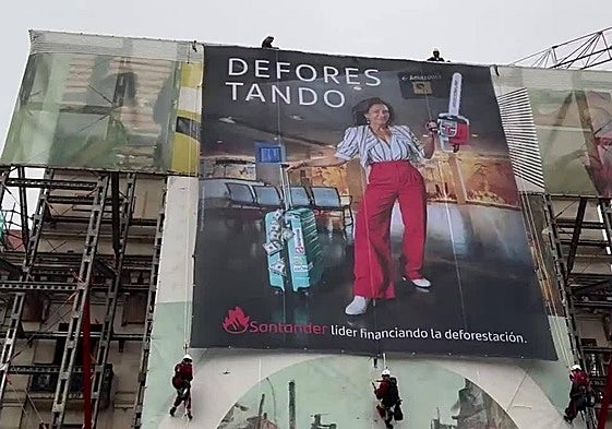 Los activistas de Greenpeace, desplegando la pancarta en la fachada del Paseo Pereda