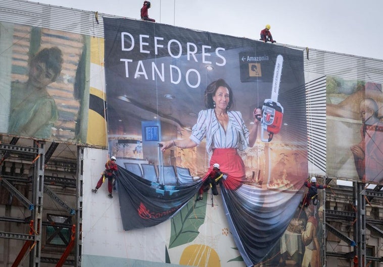 Los activistas de Greenpeace, desplegando la pancarta en la fachada del Paseo Pereda.