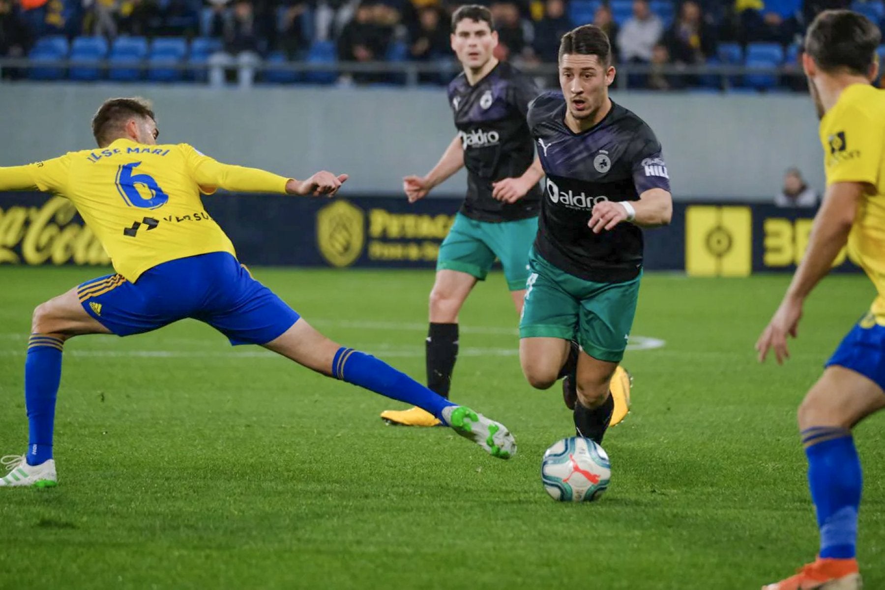 Enzo Lombardo regatea a José Mari, en presencia de Sergio Ruiz, en el partido en Cádiz de la temporada 2019-2020.