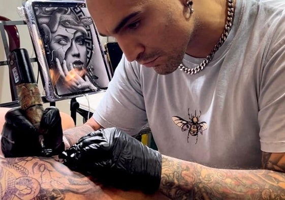 David Poncela tatúa a uno de sus clientes en el estudio 'Alma Mater Tattoo', en Santander