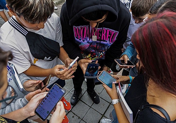 Un grupo de alumnos interactúa con sus móviles.