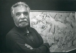 Ángel Medina en un retrato tomado, junto a una de sus obras, en una exposición de los años noventa.