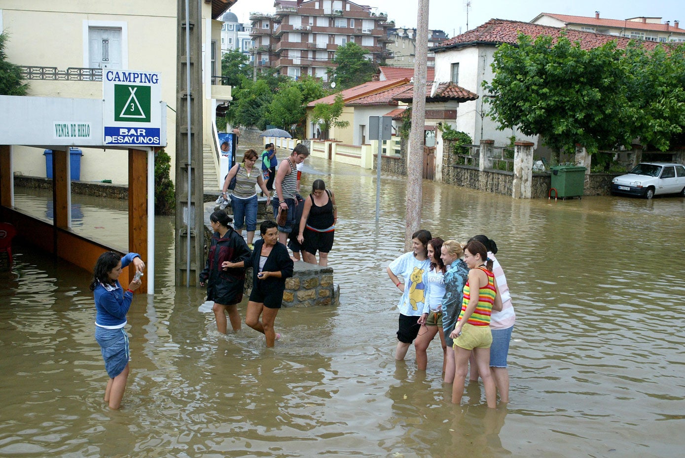 Imagen de turistas y vecinos tras una gran inundación en Suances.