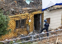 Un efectivo de la Policía Científica examina el edificio dañado por la explosión en La Albericia.