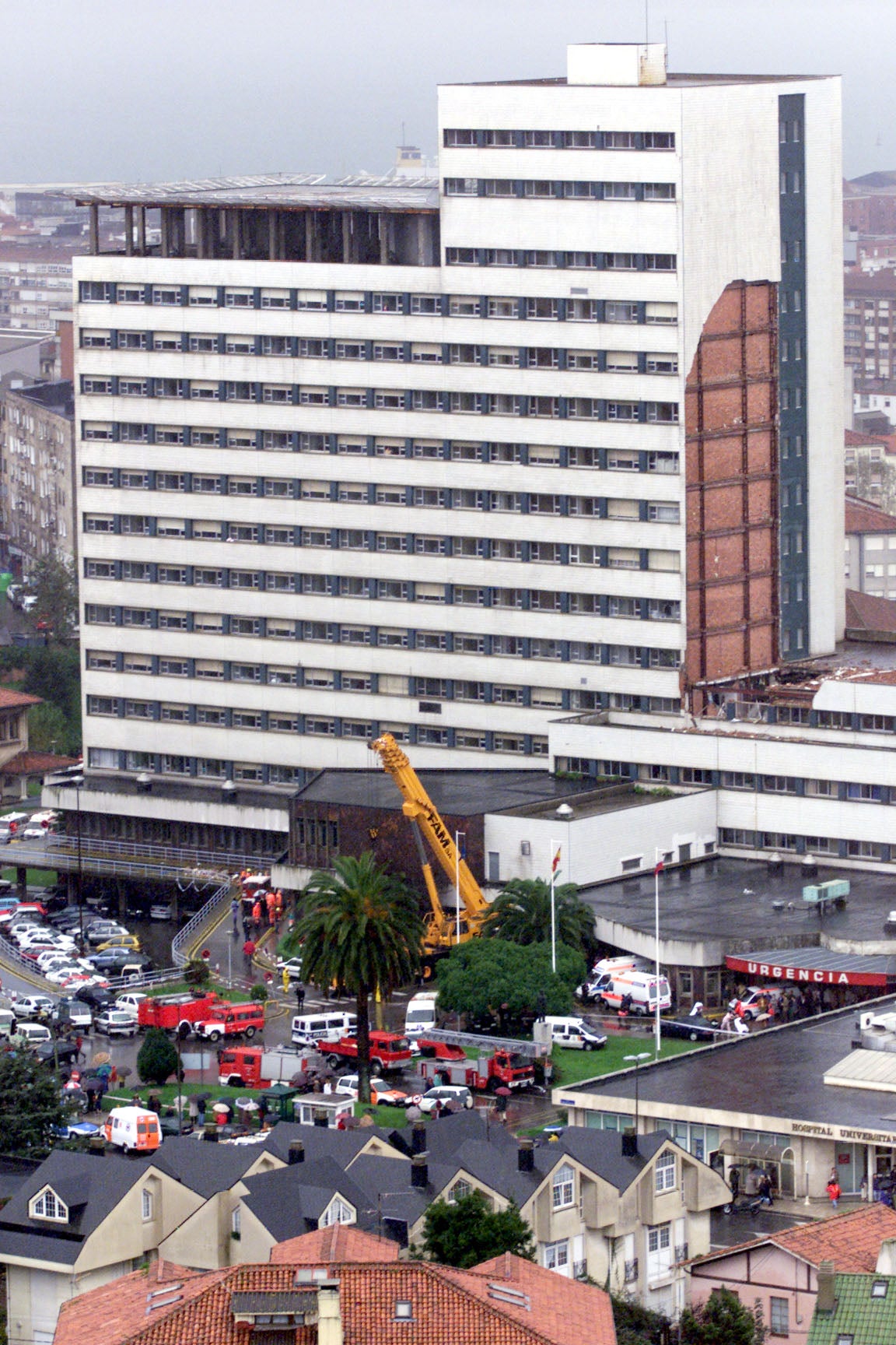 La fachada noroeste de Traumatología de Valdecilla de desplomó de cuajo como una guillotina sobre el edificio de enlace con la antigua Residencia General. En la imagen se ve la herida en el edificio y los numeros servicios de emergencias desplazados.