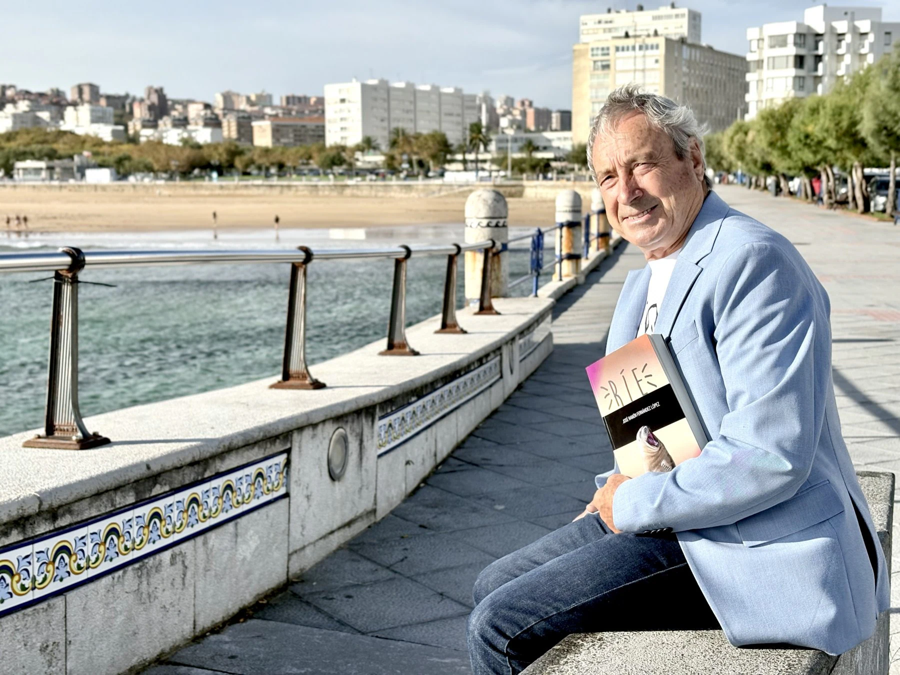 José Ramón Fernández, en El Sardinero, con su libro 'Ríe'.