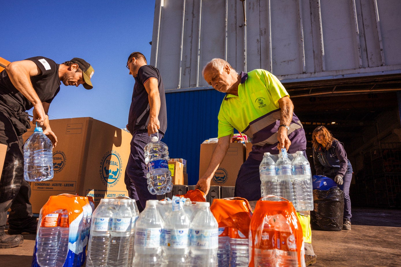 Operarios colocan las botellas de agua donadas a los damnificados por la DANA