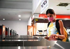 Una viajera paga con su teléfono móvil en un torno de la estación de tren de Málaga, donde se realizó un proyecto piloto.