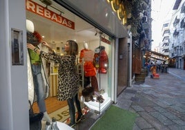 Una mujer en el escaparate de una tienda del centro de Santander.