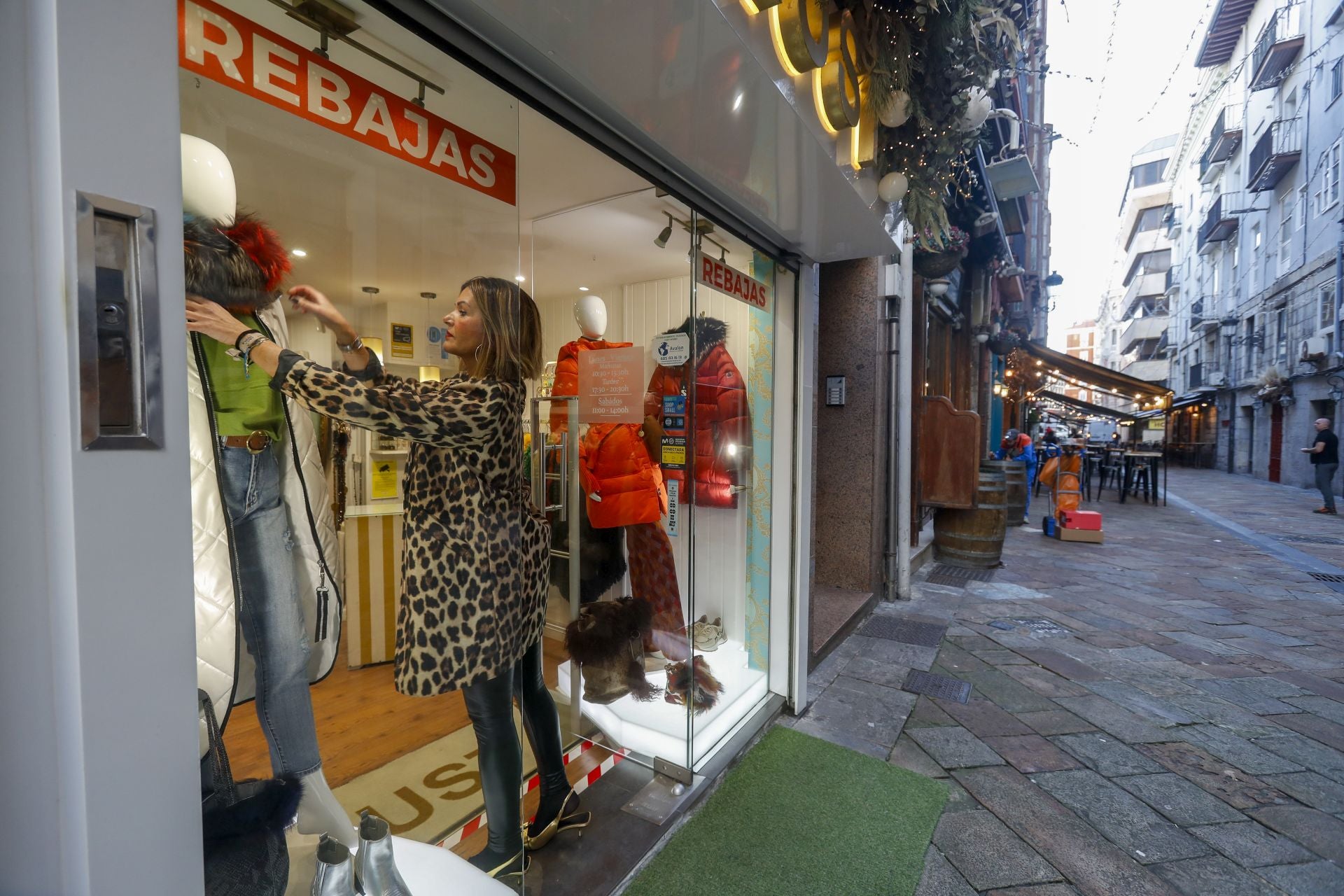 Una mujer en el escaparate de una tienda del centro de Santander.