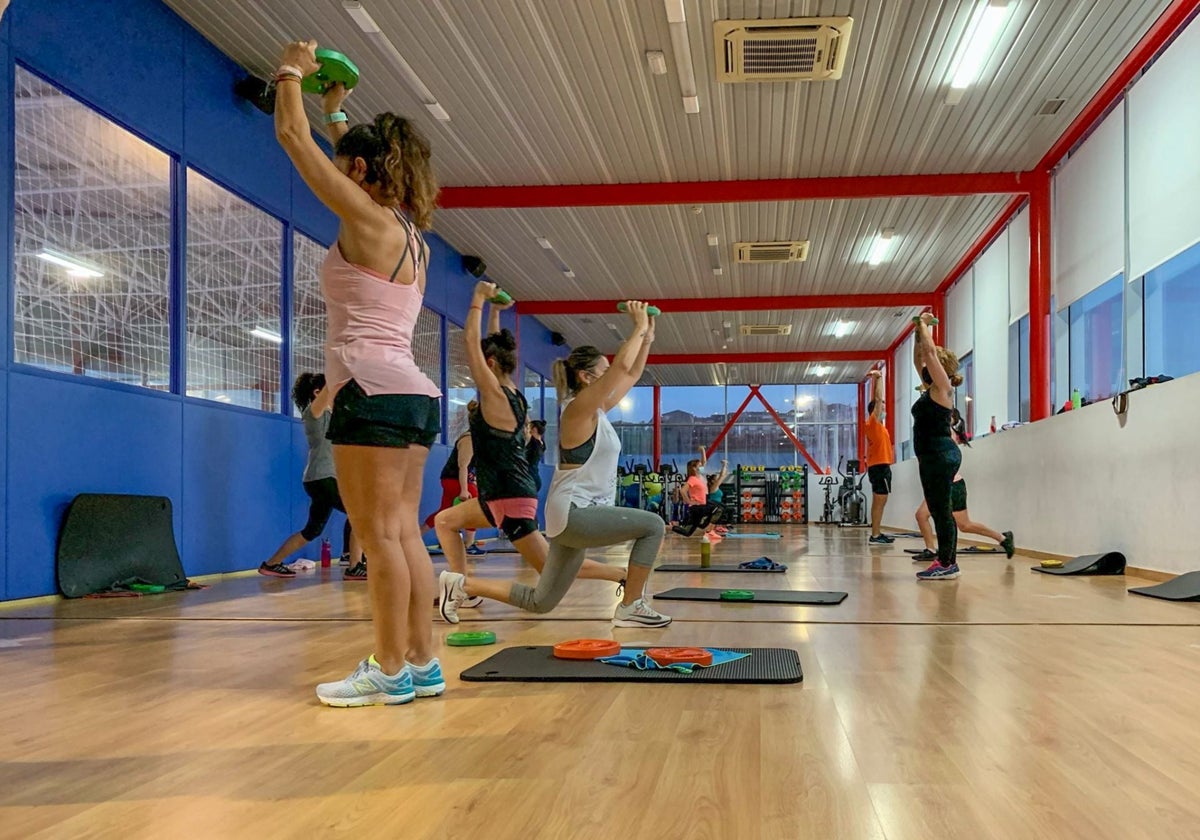 Vecinos en una clase dentro del gimnasio.