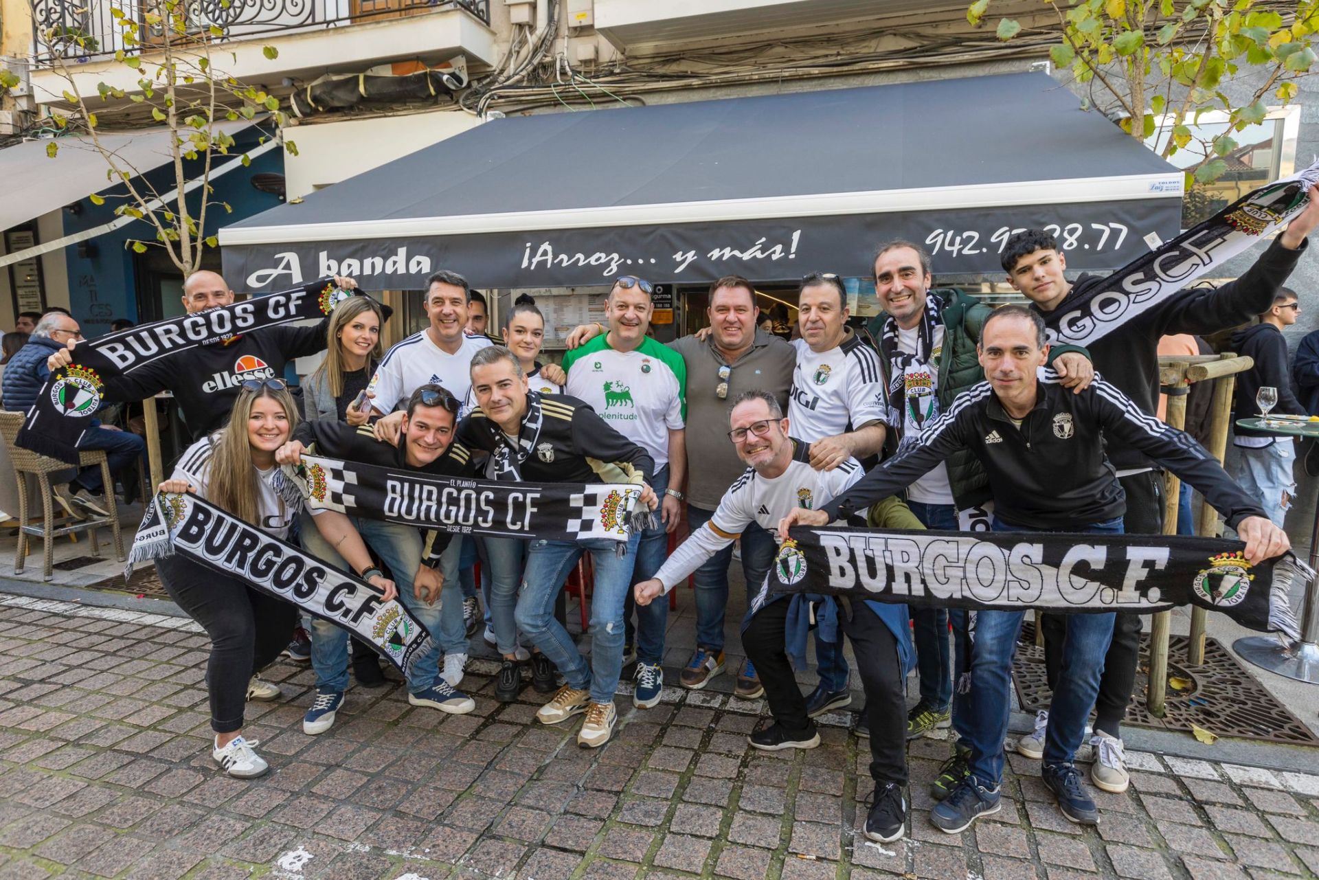 Un grupo de aficionados burgaleses, junto a uno ataviado con los colores del Racing.