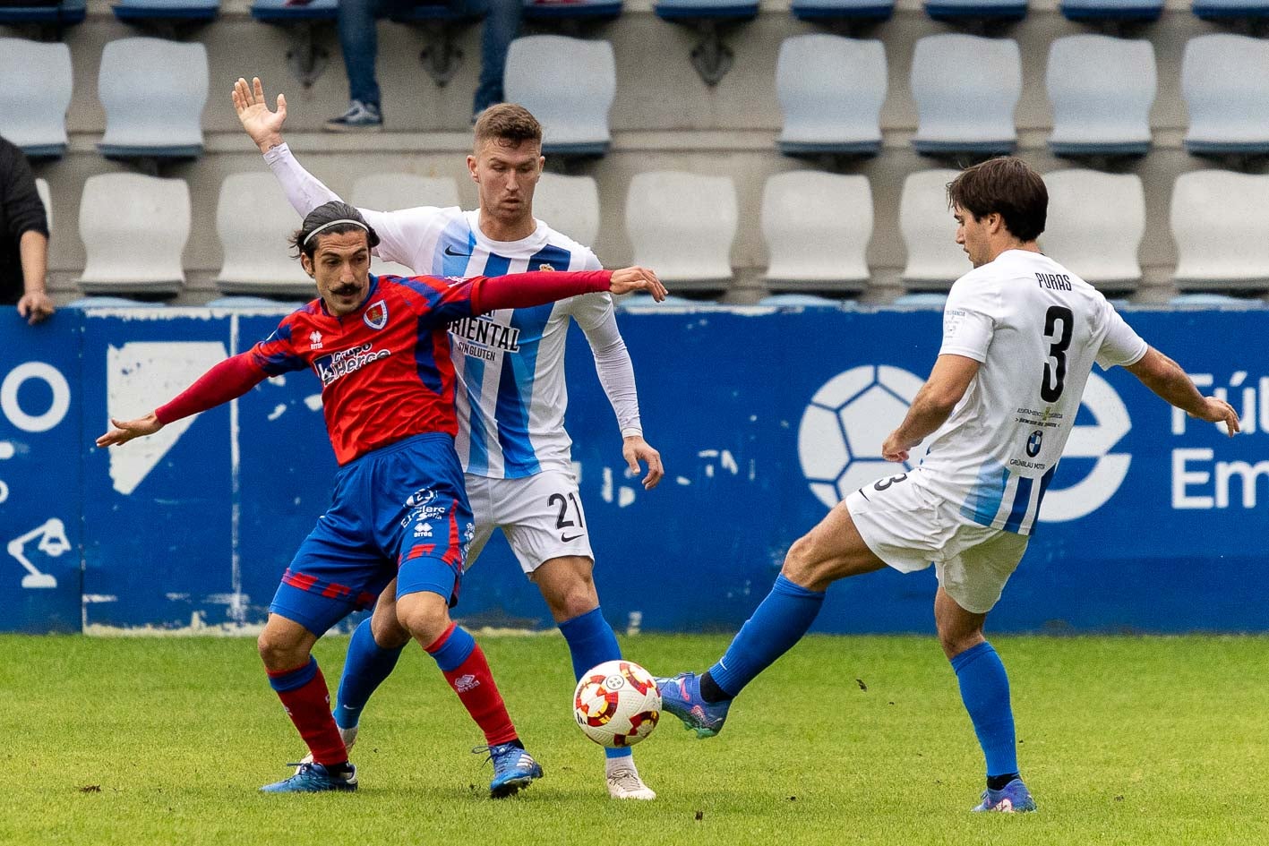 Puras (derecha) y Iago Parga pelean por la pelota con Sanchidrián, del Numancia.