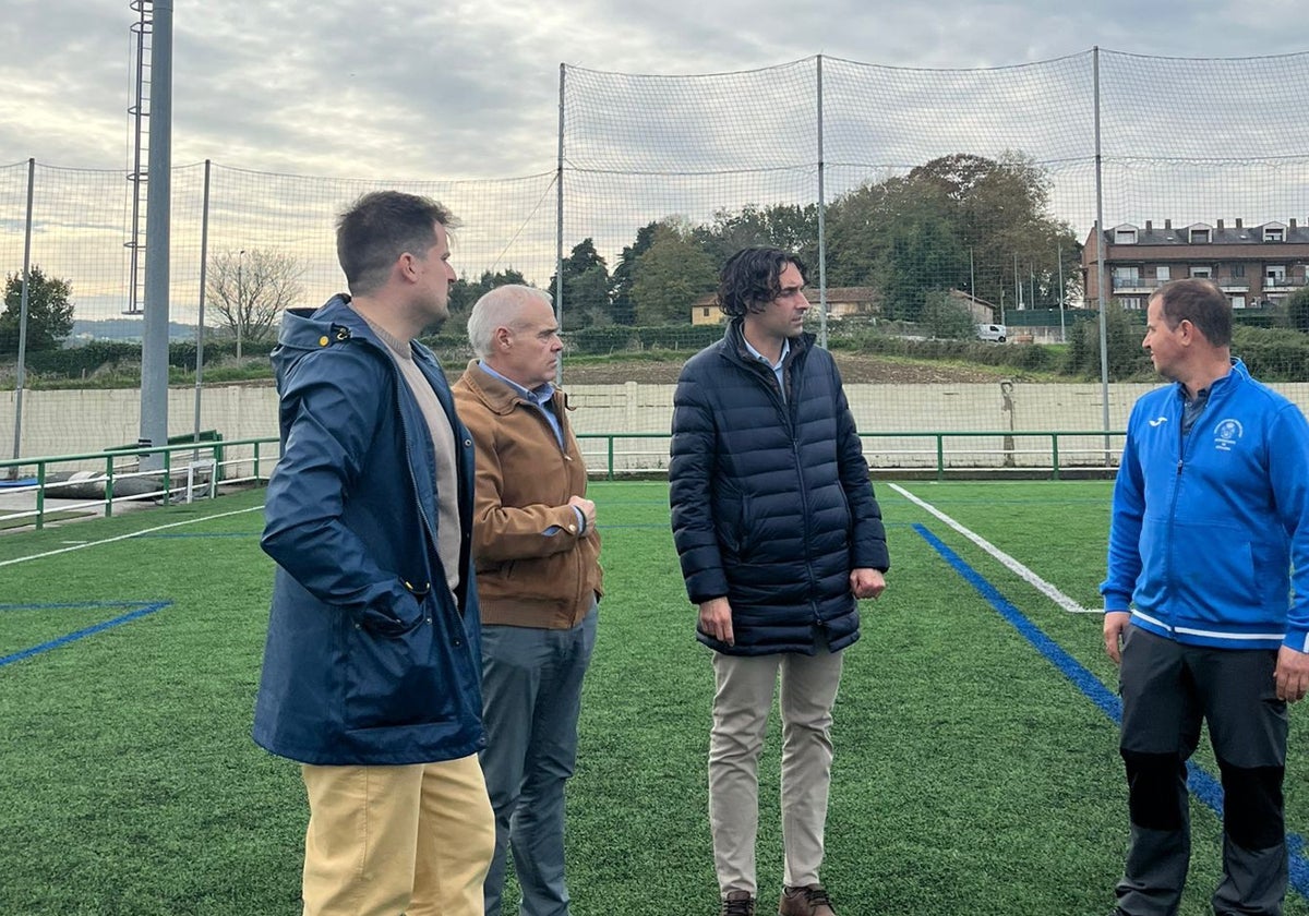 El alcalde y el concejal de deportes con técnicos en el campo de La Cultural de Guarnizo.