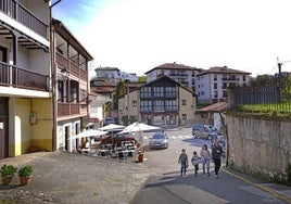 Una familia atraviesa la plaza de Fuente Real en Comillas.