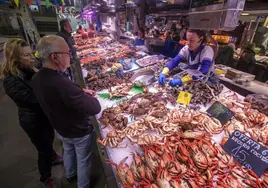 Clientes ante el mostrador de una pescadería-marisquería en el Mercado de la Esperanza de Santander.