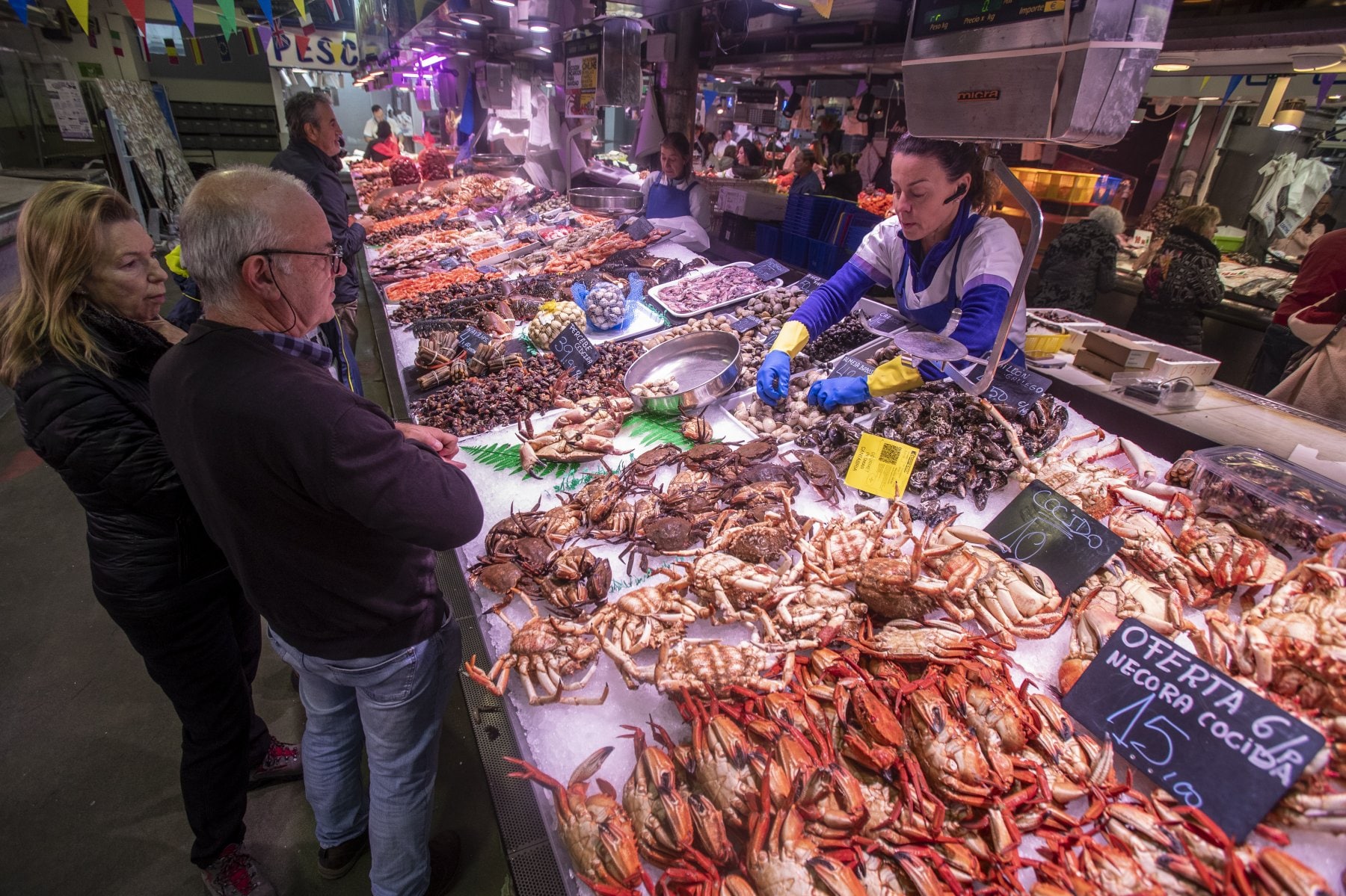 Clientes ante el mostrador de una pescadería-marisquería en el Mercado de la Esperanza de Santander.