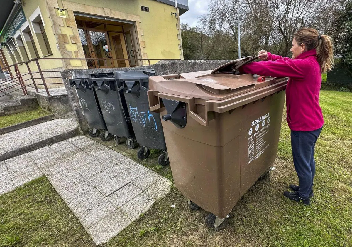 Una vecina de Piélagos deposita biorresiduos en un contenedor marrón instalado en el municipio.