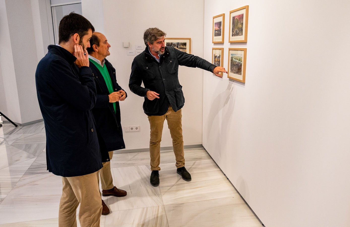 Los invitados comentan detalles de las acuarelas que integran la exposición.