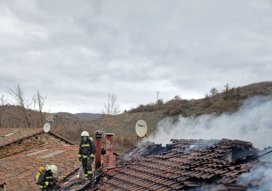 Bomberos del Gobierno regional sobre el tejado de la vivienda calcinada por el fuego.