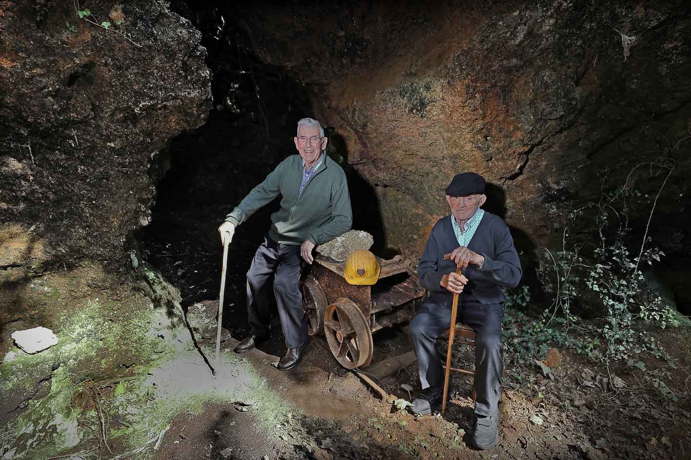 Hilario Rojo y Cesáreo Gutiérrez, ambos de 89 años, son antiguos trabajadores de las minas de Udías ahora abandonadas. En la entrada de una galería evocan las duras vivencias en aquellos años en los que la extracción de zinc, blenda y galena era su medio de vida. 