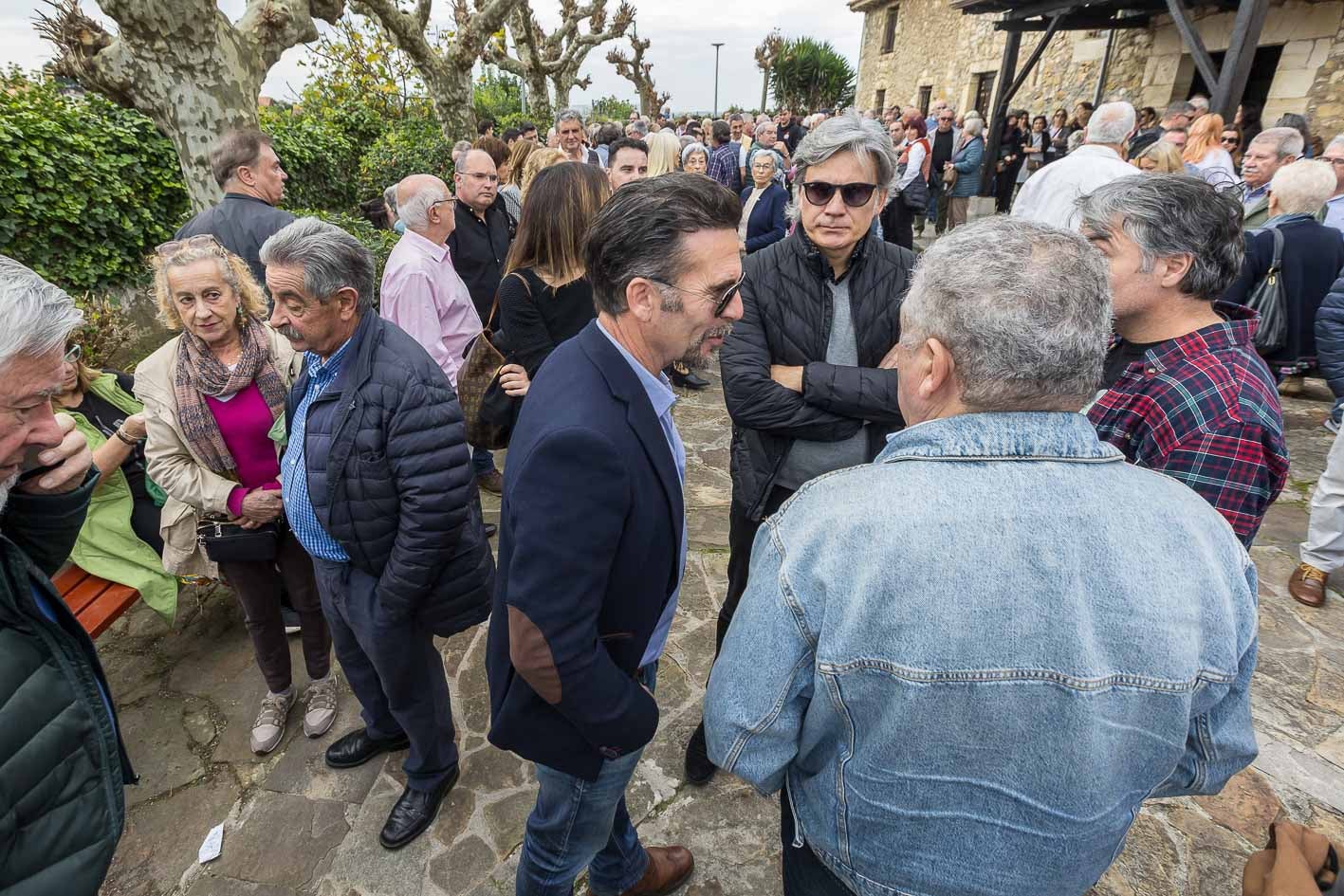 El expresidente de Cantabria, Miguel Ángel Revilla, y el músico Nando Agüeros charlan con los asistentes al funeral antes de la misa.