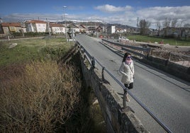 Una mujer atraviesa el viejo puente entre Reinosa y Matamorosa.