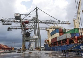 Grúas cargan un barco con mercancía en las instalaciones del Puerto de Santander.