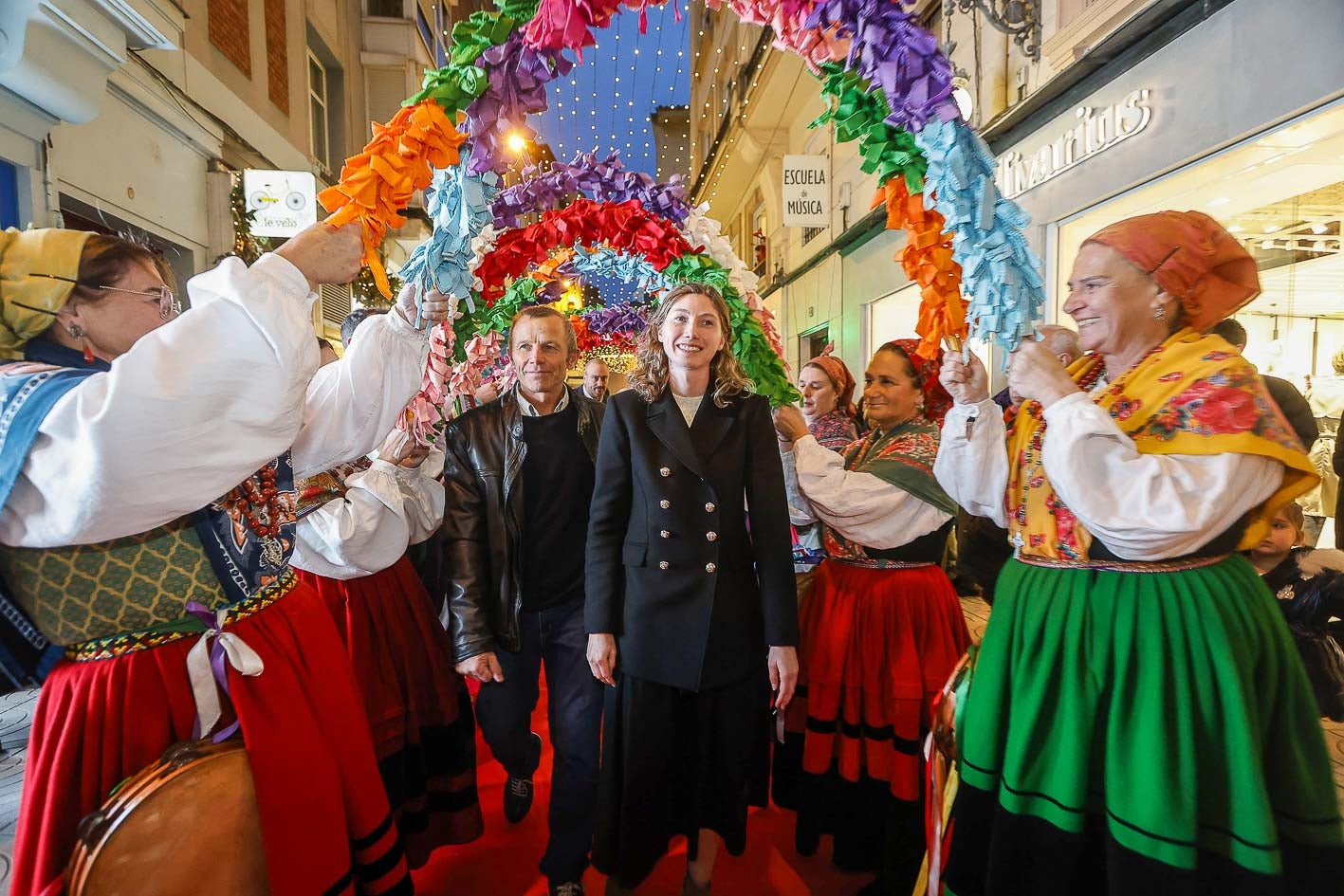 Cristina Bucsa y su padre pasan bajo los arcos floridos de la Agrupación de Danzas Virgen de las Nieves.