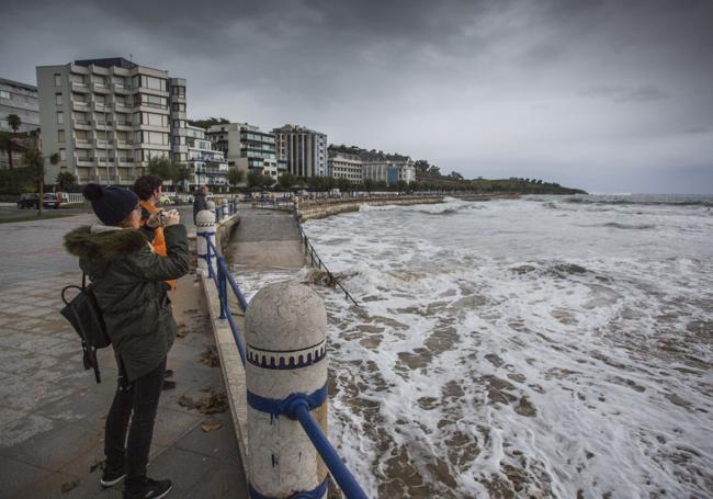 Una mujer fotografía la Segunda playa de El Sardinero en un día de temporal de 2019.