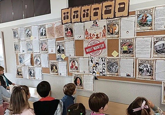 Alumnado del CEIP Costa Quebrada ante un panel con personajes históricos del proyecto 'Time Traveler.