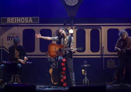 Rulo, entre Pati y Fito, interpreta una de las canciones del concierto de anoche en una figurada estación de tren de Reinosa