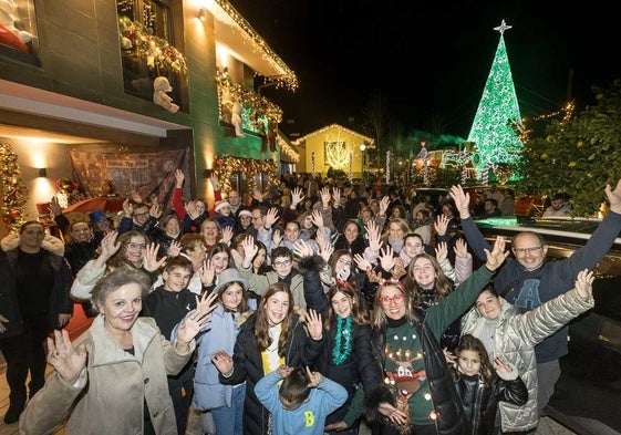 Las familias que han decorado sus hogares en Quijano posan en uno de los escenarios navideños