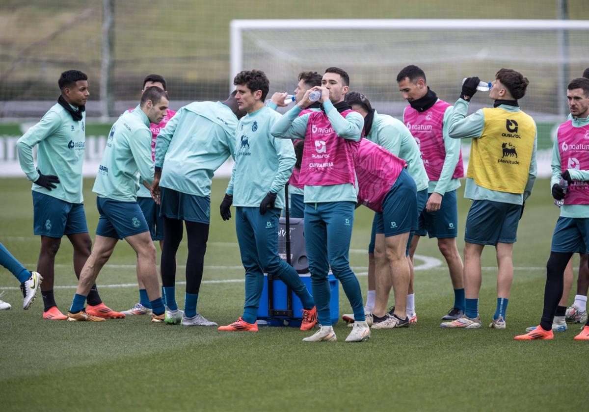 Manu Hernando apura un trago de agua en un momento del entrenamiento de ayer. Detrás, sus compañeros se toman también un respiro en La Albericia.