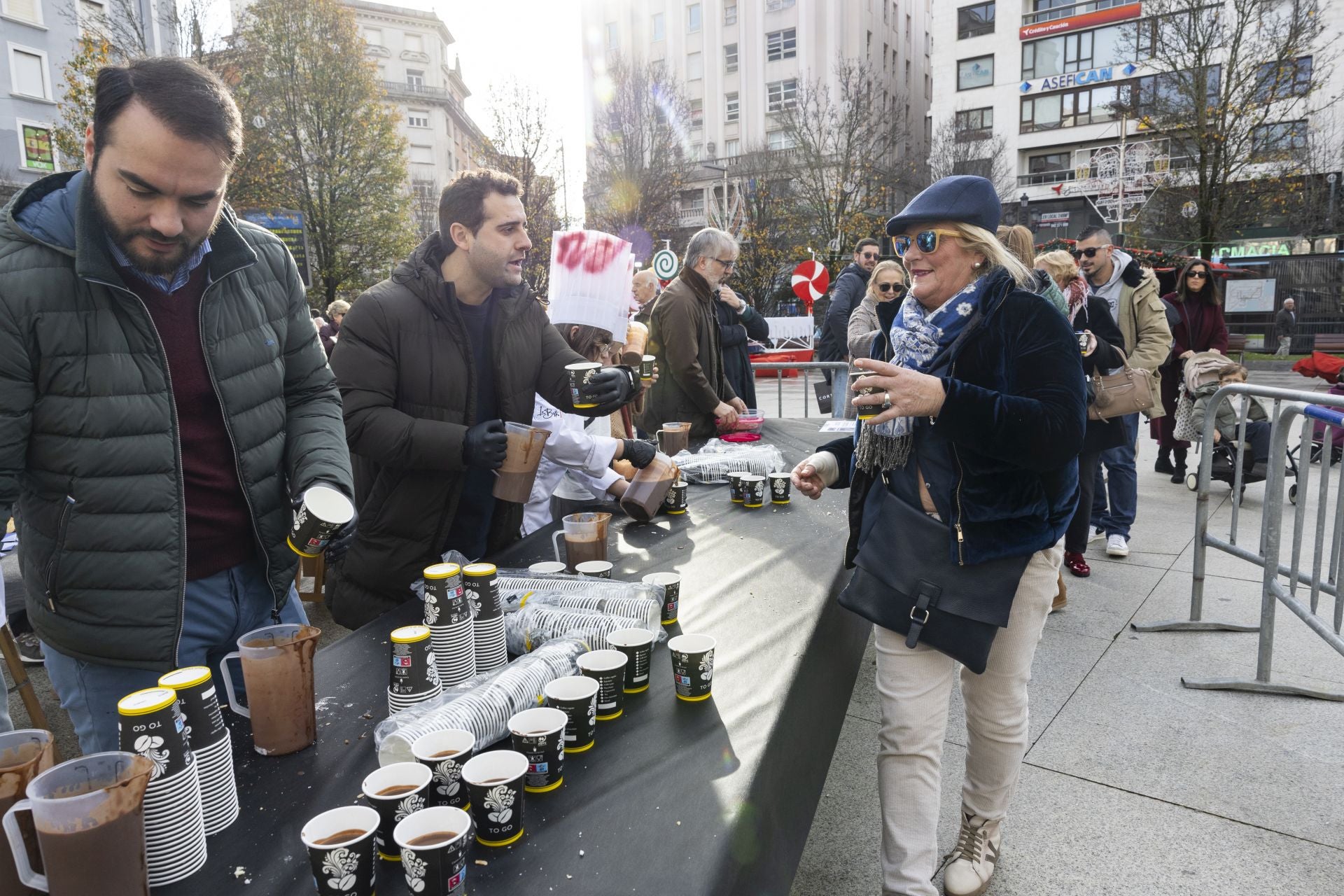 El concejal de Dinamización Social, Fran Arias, entrega un vaso de chocolate a una de las participantes.