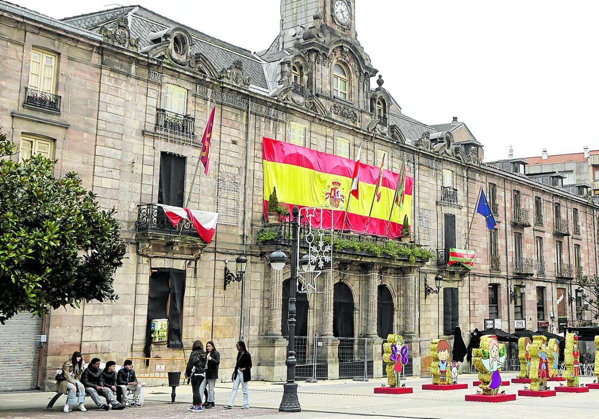 Vecinos caminan junto al histórico Ayuntamiento de Torrelavega, en el Bulevar Demetrio Herrero.